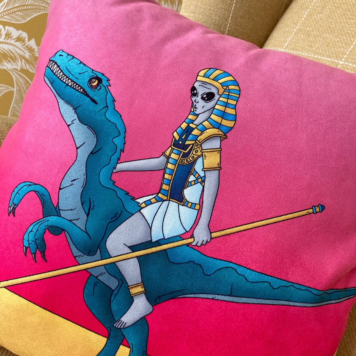 Close up of Alien rinding a dinosaur printed on faux suede cushion.